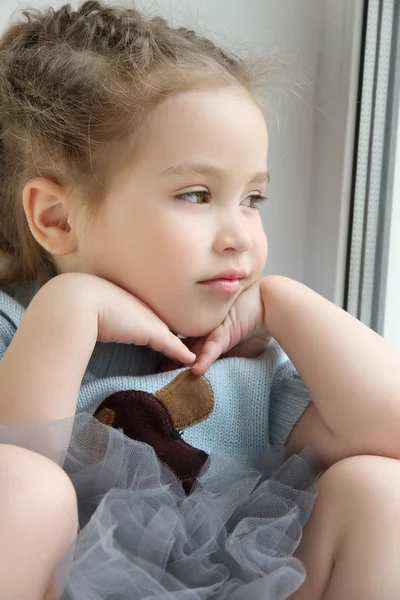 Baby girl looking out the window and dreaming — Stock Photo, Image