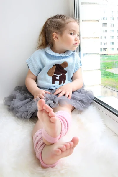 Babymeisje, zittend op de vensterbank — Stockfoto