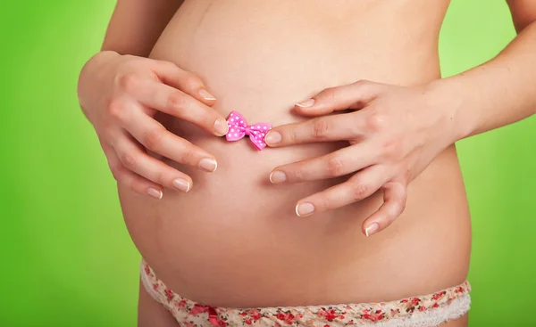 Kobieta w ciąży trzymając się za ręce jej żołądka — Zdjęcie stockowe