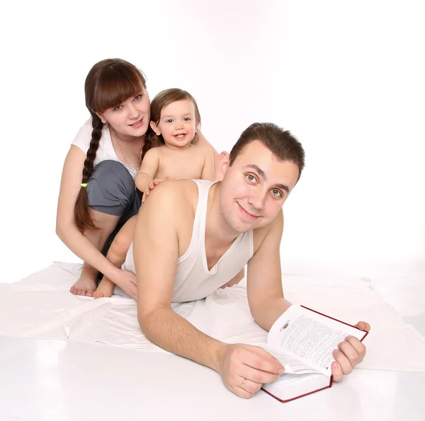 Pai, mãe e filha lêem o livro — Fotografia de Stock