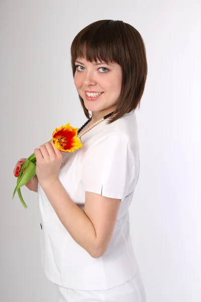 Menina com uma tulipa de flor em sua mão — Fotografia de Stock