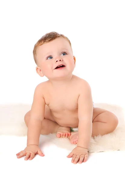 Bambino piccolo in un pannolino seduto su pelo — Foto Stock