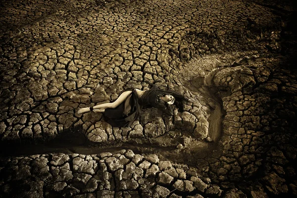 stock image Sad dirty woman is at cracked earth desert