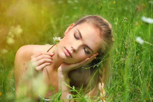 Dívka ležela na trávě s květinou — Stock fotografie