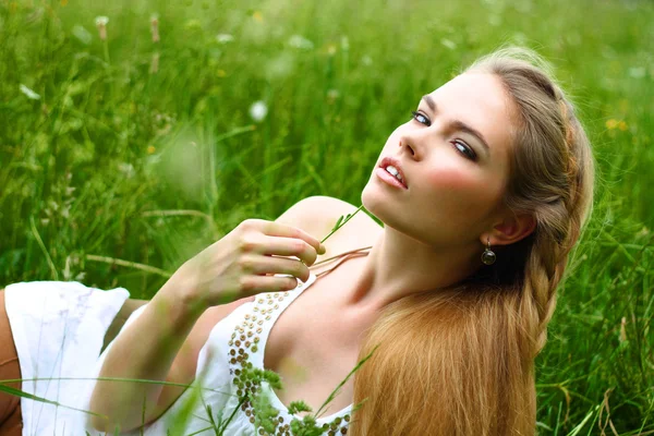 Девушка в белом платье лежит в траве — стоковое фото