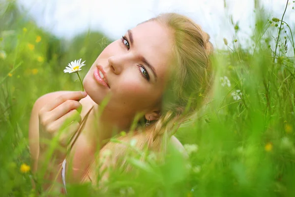 Aantrekkelijk meisje met een mooie glimlach jurk ligt in het veld een — Stockfoto