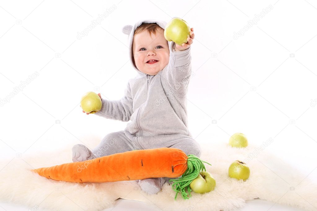 Child reaches out a green apple and smiling