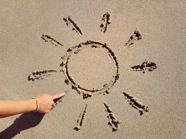 Dívka vychází slunce do písku s prstem — Stock fotografie