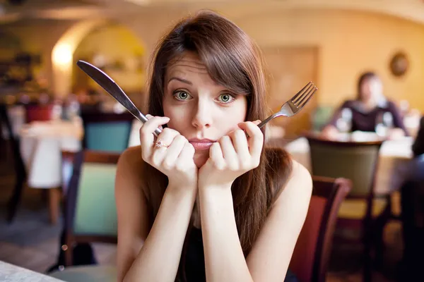 Hungry girl in a restaurant — Stock Photo, Image