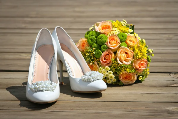 Wedding bouquet & shoes on a wooden platform — Stock Photo, Image