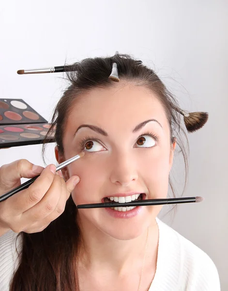 Maskenbildner tragen Make-up-Modell auf — Stockfoto