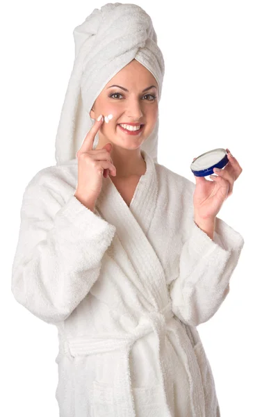 stock image Woman in bathrobe is putting the cream