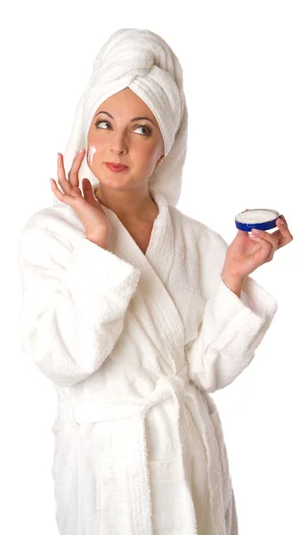 Woman in bathrobe is putting the cream — Stock Photo, Image