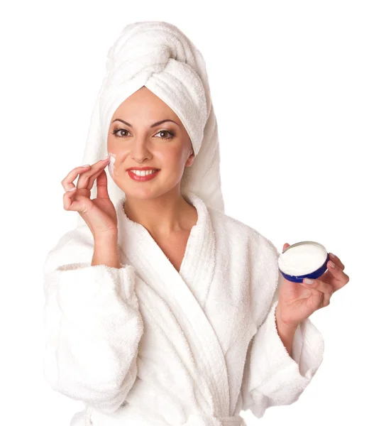 stock image Woman in bathrobe is putting the cream