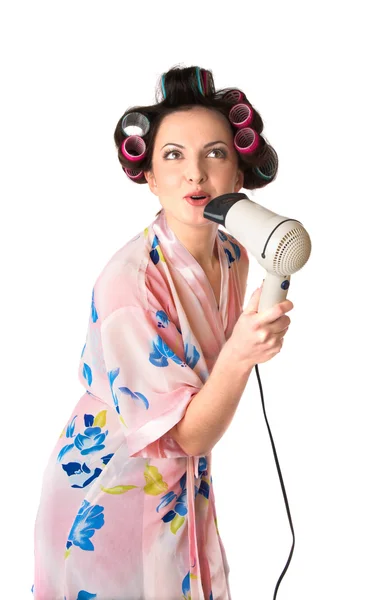 Woman sings karaoke on hair dryer Stock Photo