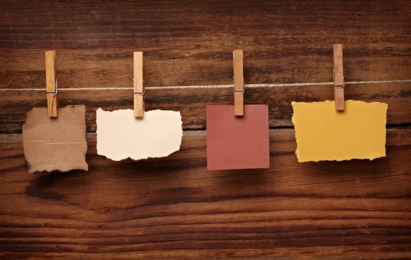 Grunge-Notizpapier und Wäscheklammer auf Holz — Stockfoto