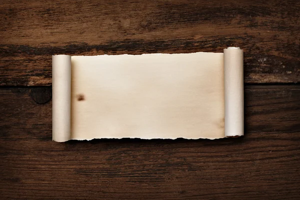 Papel de pergamino rizado arrugado sobre madera — Foto de Stock