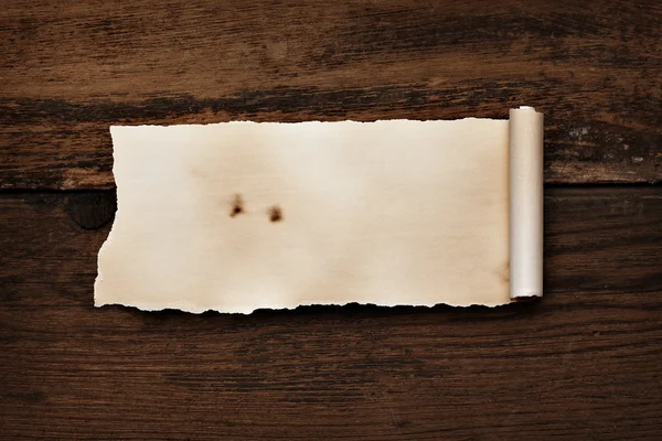 Papel de pergamino rizado arrugado sobre madera — Foto de Stock