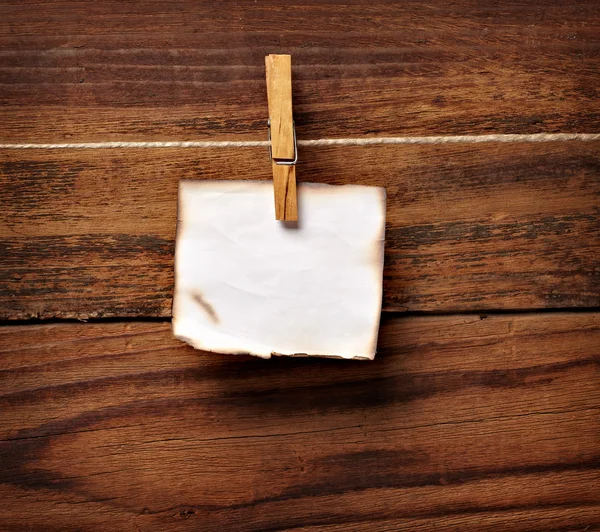 Grunge note paper and clothes peg on wood — Stock Photo, Image