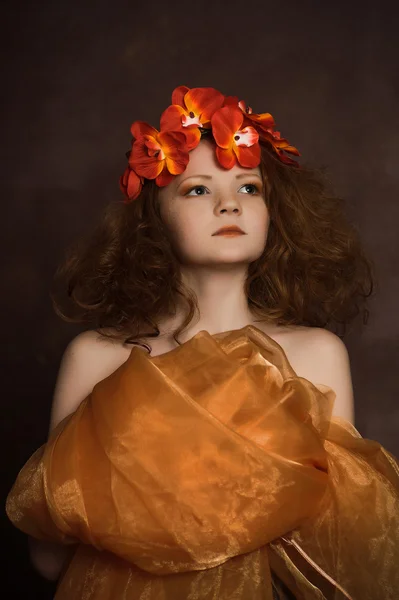 Teenie-Mädchen in einem Kranz aus roten Blumen — Stockfoto