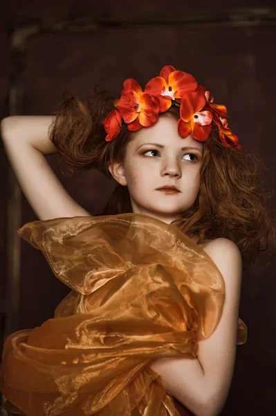 Έφηβος κορίτσι σε ένα στεφάνι από κόκκινα λουλούδια — Φωτογραφία Αρχείου