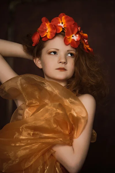 Teenie-Mädchen in einem Kranz aus roten Blumen — Stockfoto