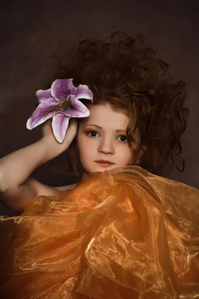 Κορίτσι με λιλά κρίνοι στα μαλλιά της — Φωτογραφία Αρχείου