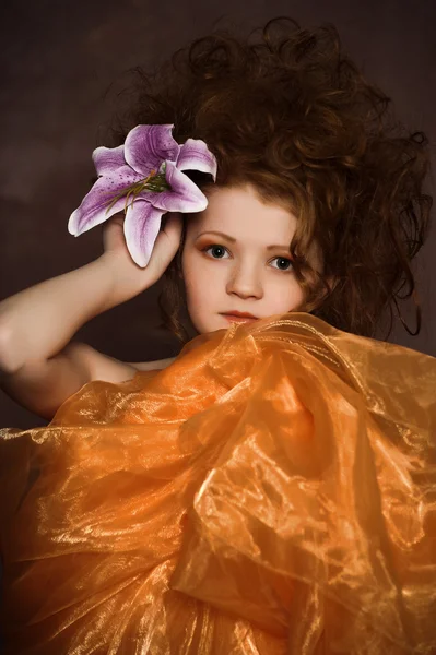Flicka med mörklila liljor i håret — Stockfoto