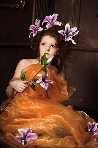 Mädchen mit lila Lilien im Haar — Stockfoto