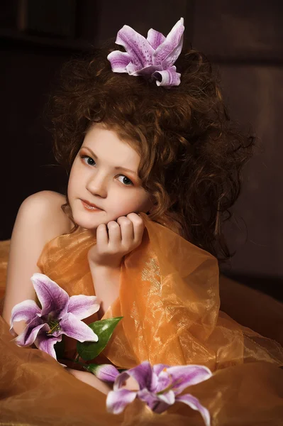 Mädchen mit lila Lilien im Haar — Stockfoto