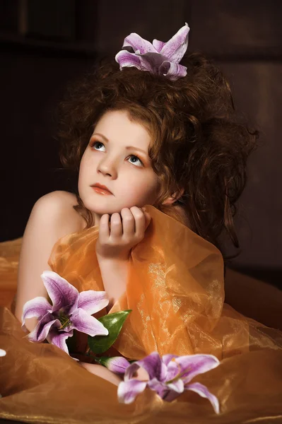 Flicka med mörklila liljor i håret — Stockfoto