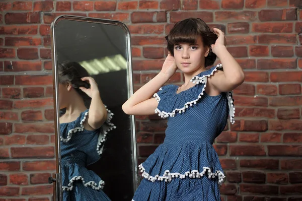 The girl admires itself in a mirror — Stock Photo, Image
