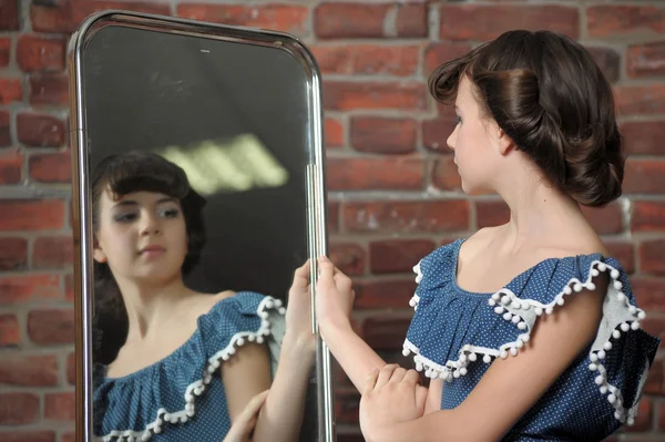 Het meisje bewondert zelf in een spiegel — Stockfoto