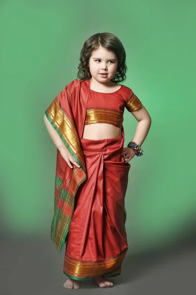 Una niña en la naturaleza con un disfraz hindú.