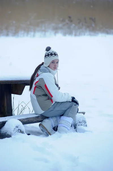 En vacker flicka i parken i vinter. — Stockfoto