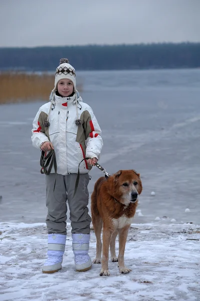 Teen ragazza a piedi un grande cane in inverno — Foto Stock