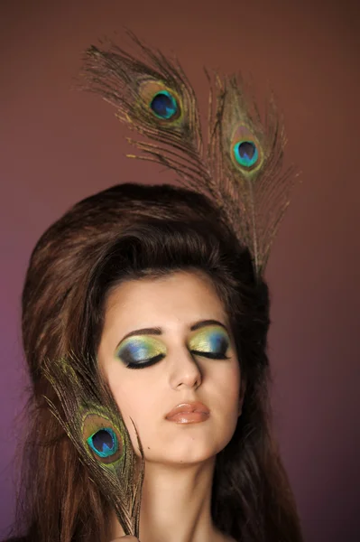Portarit of beautiful young girl with peacock feather — Stock Photo, Image