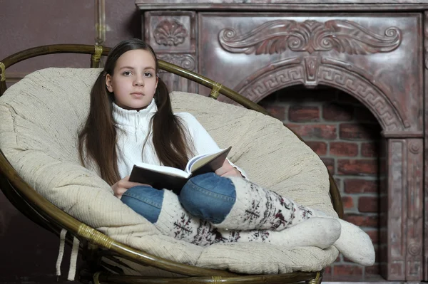 十几岁的女孩坐在椅子上看书 — 图库照片