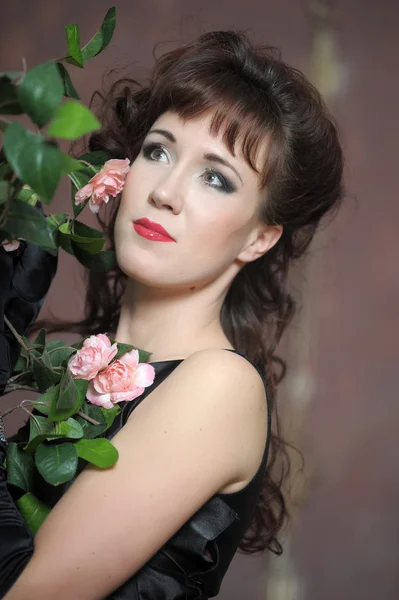 Giovane donna accanto a un cespuglio di rose — Foto Stock
