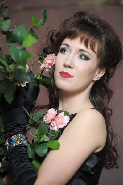 Молодая женщина рядом с кустом роз — стоковое фото