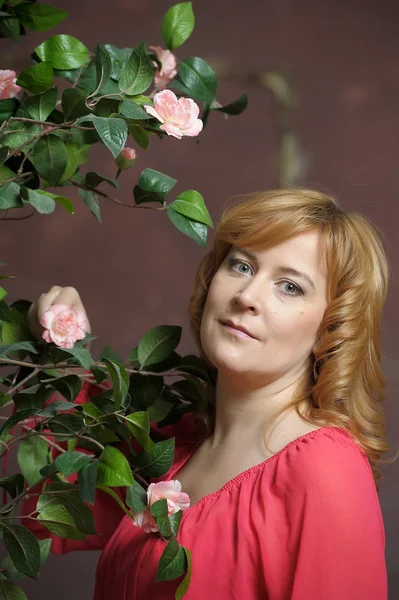 Молодая женщина рядом с кустом роз — стоковое фото