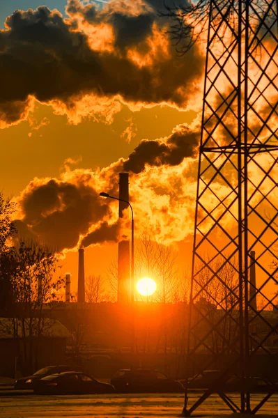 Roken van fabriek schoorstenen bij zonsondergang — Stockfoto