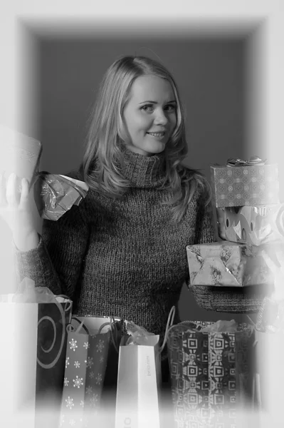Молодая женщина с большим количеством подарков — стоковое фото