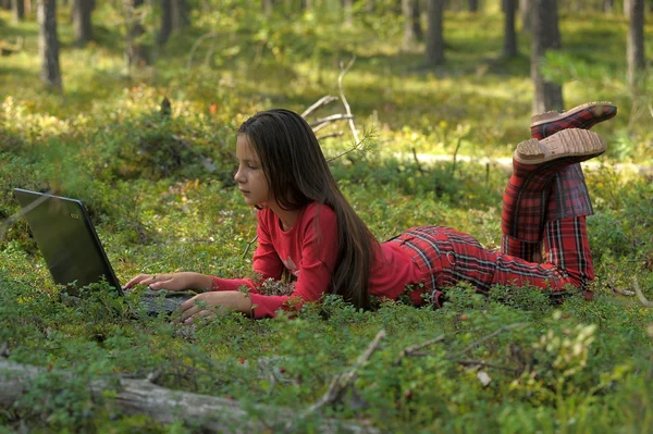 Красива дівчина з ноутбуком в лісі — стокове фото