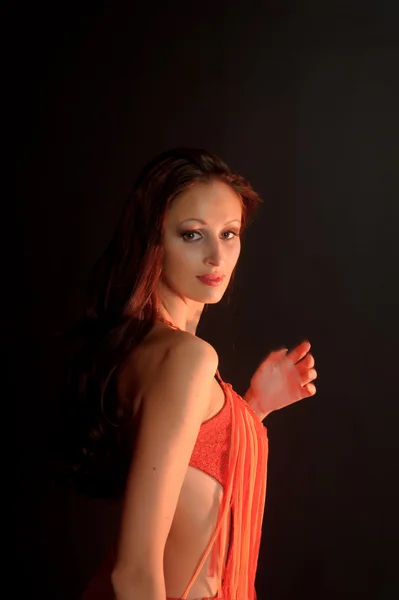 Mooie donkerharige vrouw in een rode jurk — Stockfoto