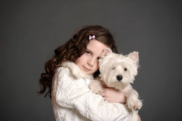Menina bonita com um cão fofo branco — Fotografia de Stock