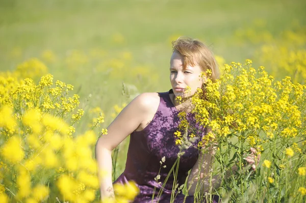 Flicka avkopplande i fält av blommor — Stockfoto