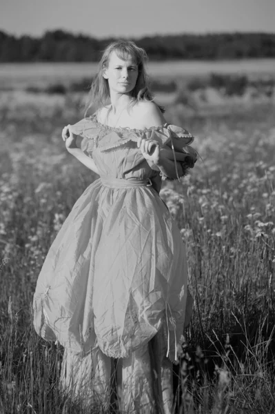 Mladá žena v retro oblečení v poli — Stock fotografie