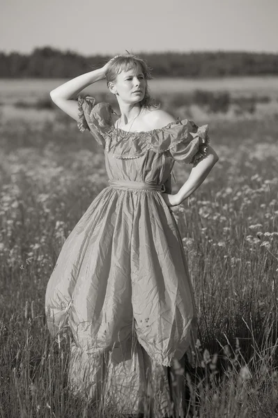 Mladá žena v retro oblečení v poli — Stock fotografie
