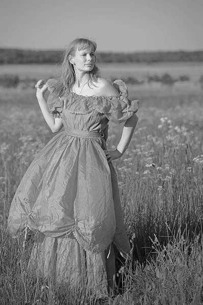 Jonge vrouw in een retro jurk in het veld — Stockfoto